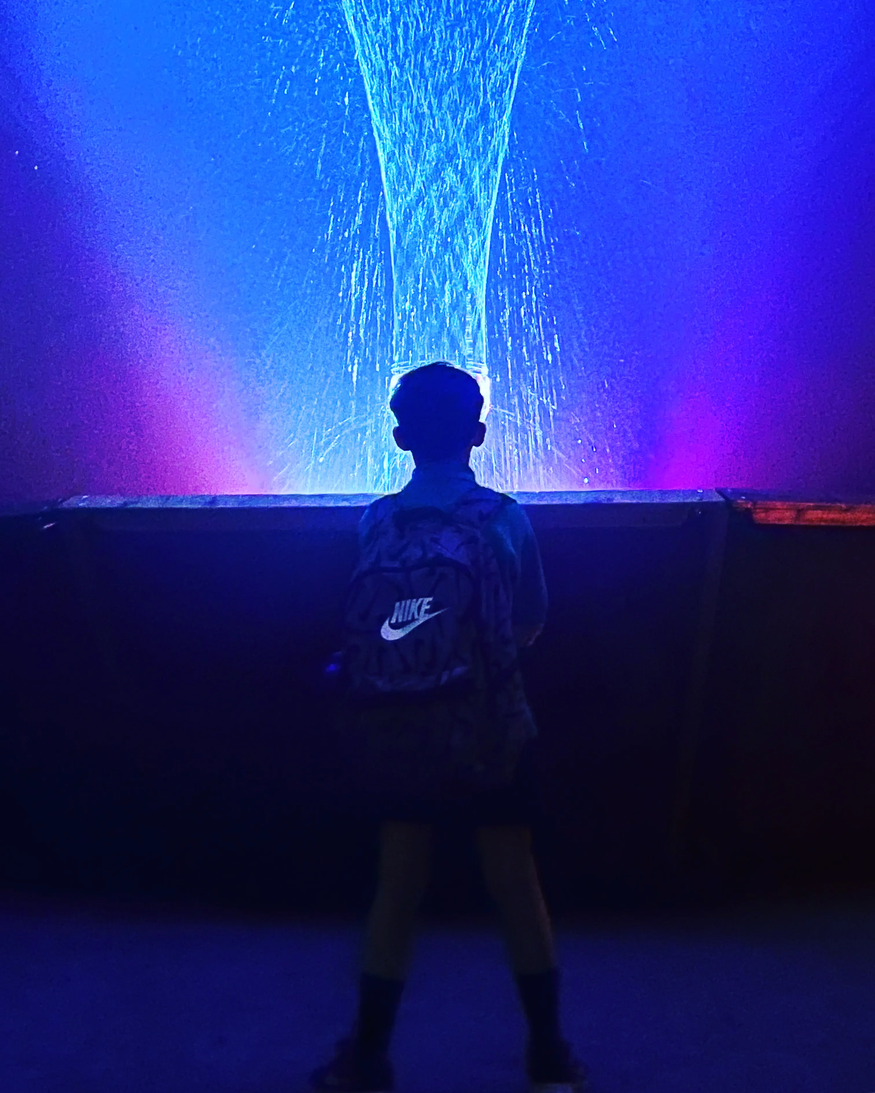 A child stares, transfixed, at the dancing fountain