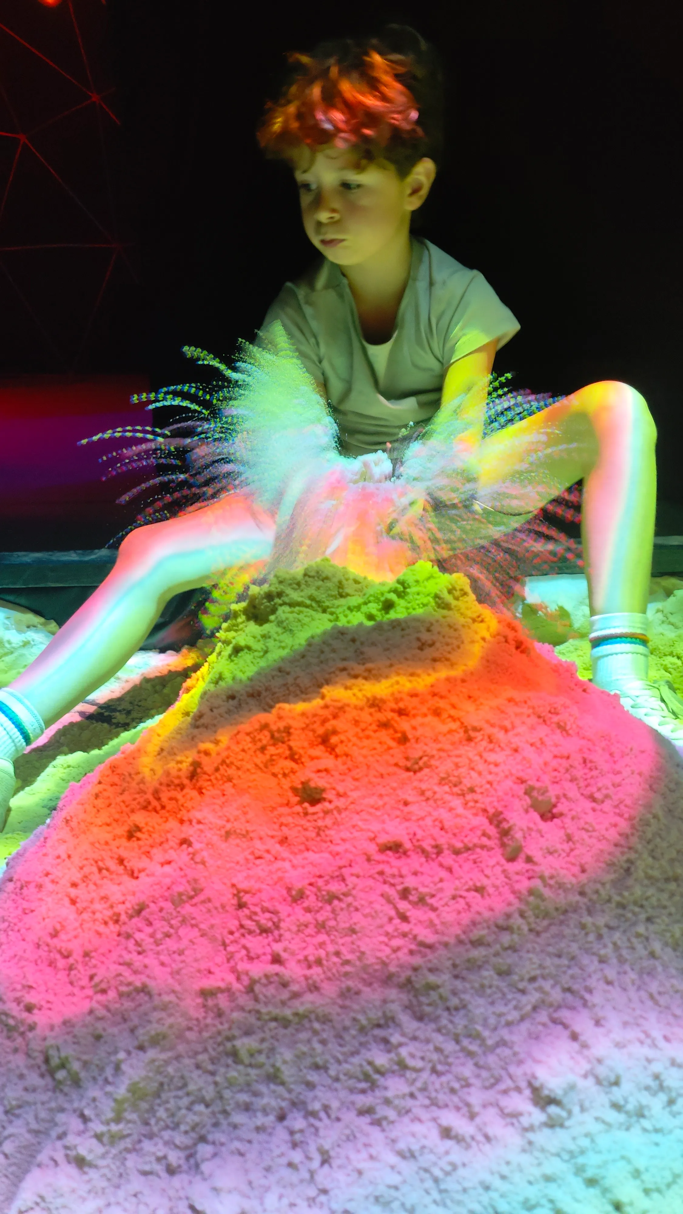 A child throwing sand in the AR sandpit